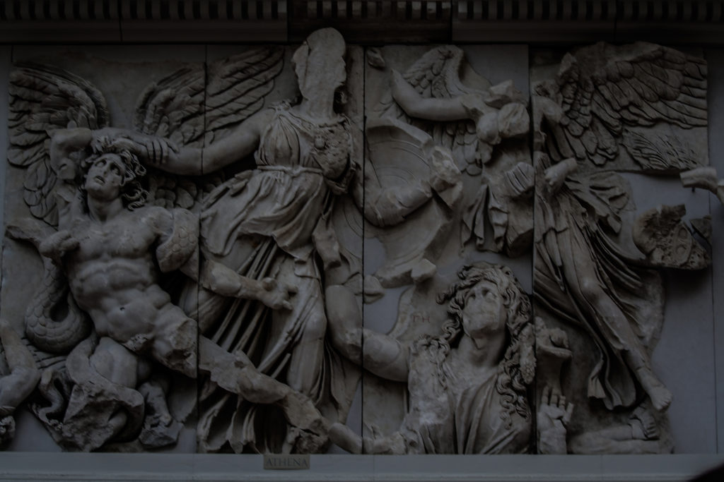 Pergamon Altarpiece. Built by order of Eumenes II Soter. 164-156 B.C. by artists of the school of Pergamon. Marble and Limestone. East frieze. Gigantomachy. Struggle between gods and giants. Athena taking the young Alcyoneus by the hair while his mother, Gaia leaves the ground due to the death of her son. Next, the winged Nike. Pergamon Museum, Berlin, Germany